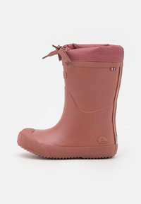 Rubberen enkelboot in stofroze met een zachte, gestructureerde bovenkant en een trekkoordsluiting. Voorzien van een stevige zool en een klein logodetail.