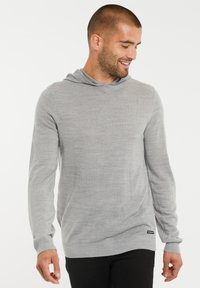 Grijze hoodie met lange mouwen en een relaxte pasvorm, gemaakt van zachte, gestructureerde stof. Beschikt over een capuchon en ribbelboorden aan de mouwen en onderkant.