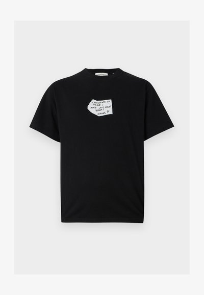 Melnas kokvilnas t-krekls ar īsām piedurknēm, priekšpusē ar roku rakstītu balto tekstu, kas līdzinās piezīmei.