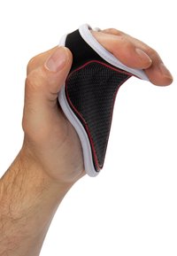 Zwart textuur grip pad met witte en rode accenten, die door een hand wordt samengedrukt. Rond formaat, ontworpen voor verbeterde controle en comfort.