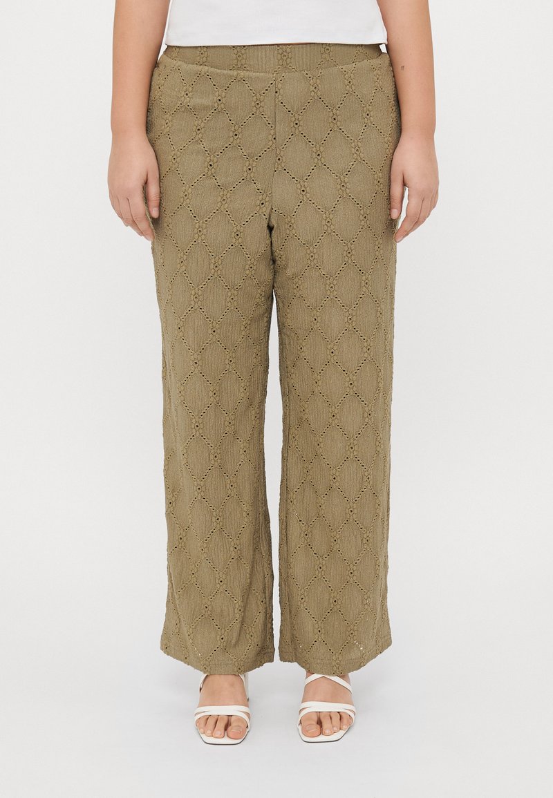 Λαδί παντελόνι σε ίσιο σχέδιο με υφή διαμαντιού και αφρώδες σχέδιο στο τελείωμα, συνδυασμένο με λευκές σαμπό με λουράκια.