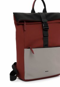 Zaino a rullo rosso e grigio realizzato in materiale resistente, dotato di un cappuccio nero, spallacci regolabili e una tasca frontale con zip.