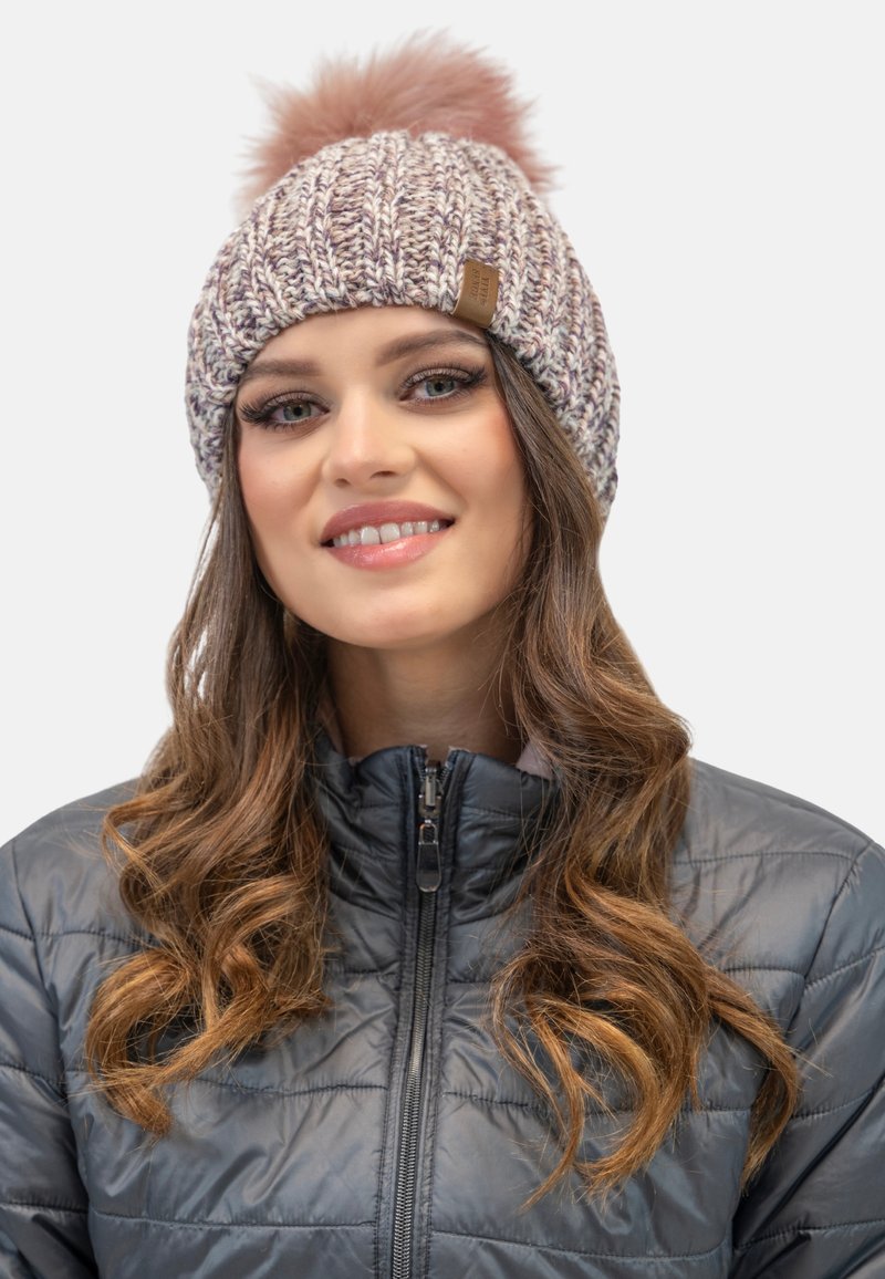 Căciulă tricotată în nuanțe pastel de mov și bej, cu un pom-pom pufos roz în vârf. Material texturat și un detaliu mic din piele cu logo.