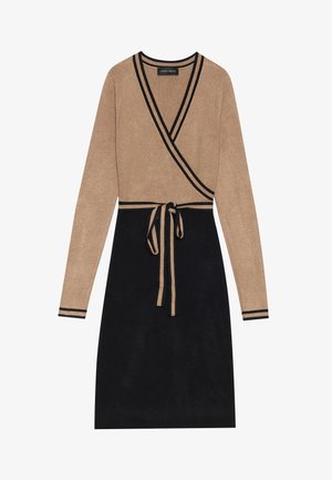 Robe portefeuille avec un haut beige et une jupe noire. Manches longues avec des rayures noires, détail de ceinture à nouer, texture ribaffée sur l'ensemble.