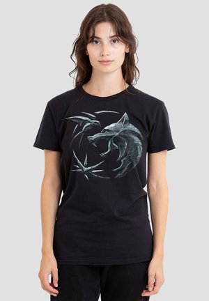 Schwarzes Baumwoll-T-Shirt mit einem aufgedruckten grauen Wolf und abstraktem Design auf der Vorderseite. Rundhalsausschnitt, kurze Ärmel, legerer Schnitt.