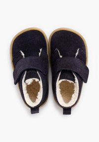 Tmavě námořnické boty s měkkou vlněnou vložkou, opatřené suchým zipem a gumovou podrážkou. Zaoblená špička a viditelné boční švy.