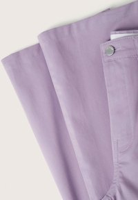 Pantalon lilas à texture lisse, avec une poche latérale, des coutures blanches et un détail de bouton argenté sur la ceinture.