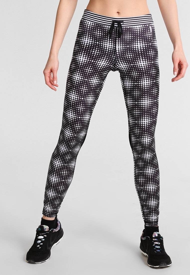 Leggings a pois bianco e nero con un design aderente, dotati di una vita elastica e laccetto, realizzati in un materiale elasticizzato.