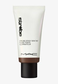Klemrør av MAC Strobe Dewy Skin Tint med en hvit kropp, svart tekst og en brun bunn, toppet med et svart hette.