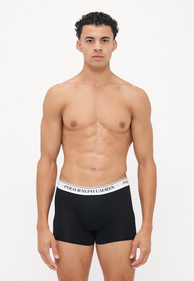 Črne bokserice z belim elastičnim pasom, na katerem je logotip "POLO RALPH LAUREN." Tkanina deluje gladko in se prilega.