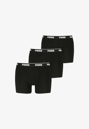 Trzy czarne bokserki Puma z białym logo Puma na elastycznym pasku, ułożone w stopniowany rząd na białym tle.