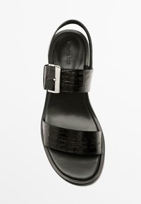 Sort lædersandal med krokodilletekstur, to brede stropper, sølvspænde og åben hæl. Glat overflade; minimalistisk design.