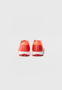 Pantofi sport roșii cu un material superior texturat, talpă intermediară albă contrastantă și un design detaliat al călcâiului. Potriviți pentru activități sportive.