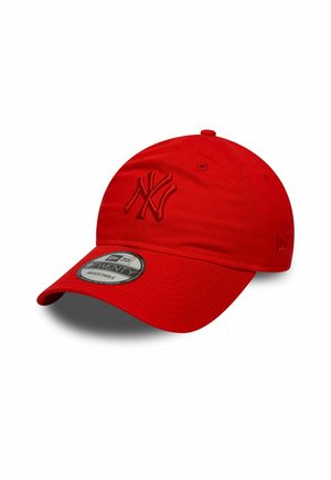 Casquette de baseball rouge avec un logo NY brodé, faite d'un tissu à texture lisse. Elle dispose d'une visière structurée et incurvée ainsi que d'une sangle ajustable.