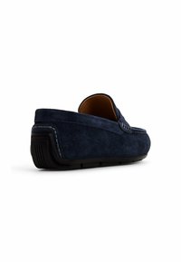 Mocassini in suede blu navy con design slip-on, suola in gomma e cuciture a contrasto. Forma arrotondata con tacco basso e fodera interna liscia.