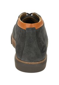 Graue Wildleder-Stiefeletten mit einem braunen Lederakzent am Schaft, runder Zehenform und strukturiertem Gummisohle. Schlichte Nahtdetails.