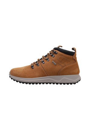 Zapato de senderismo de caña alta marrón con cuello acolchado negro, ojales metálicos, cordones marrones claros, suela beige texturizada y dibujo antideslizante.