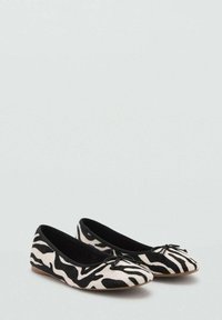 Balerinke v črno-belem zebričastem vzorcu, z mehko teksturo, okroglo konico in majhnim poudarkom v obliki pentlje spredaj.