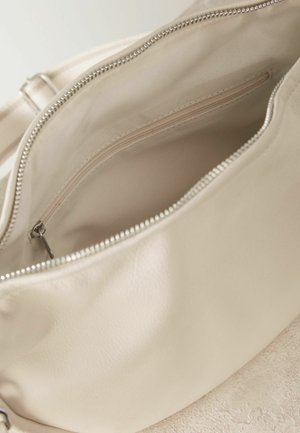 Beige leather bag interior, featuring a zippered pocket and smooth fabric lining. The bag has a rounded shape and silver hardware.