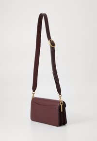 Burgundy leather shoulder bag with a smooth finish, rectangular shape, gold hardware accents, and an adjustable strap.