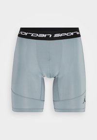 Lys grå sports shorts med en elastisk sort talje, der har teksten "Jordan Sport". Inkluderer et lille sort Jordan logo på siden.