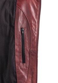 Burgunderfarbene Lederjacke mit einem schwarzen Stoffeinsatz, ausgestattet mit einer seitlichen Reißverschlusstasche und glatter Oberflächenstruktur, betont durch kontrastierende Nähte.