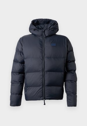 Tummansininen puhallettava takki hupulla, jossa on tilkkutöitä, etuvetoketju ja EA7-logo vasemmassa rinnassa. Sujuva pinta.