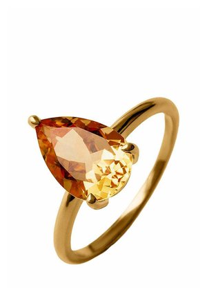 Anillo de oro con una gema naranja en forma de pera sostenida por tres garras sobre una banda lisa y pulida contra un fondo blanco.