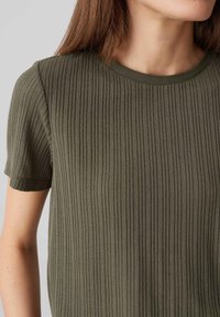 Olive green ribbed t-shirt with short sleeves and a round neckline, featuring a textured fabric with vertical stripes.