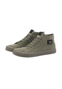 Zapatillas altas en lona verde oliva con un acabado texturizado, suelas de goma y un detalle de parche lateral. Presentan ojales de metal y cordones.
