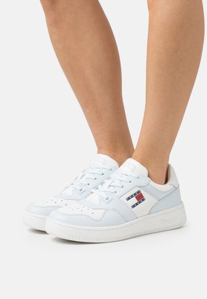 Sneaker sportive bianche e azzurre chiaro con una texture in pelle liscia, punta perforata e accenti del logo sul lato. Suola in gomma per una maggiore aderenza.