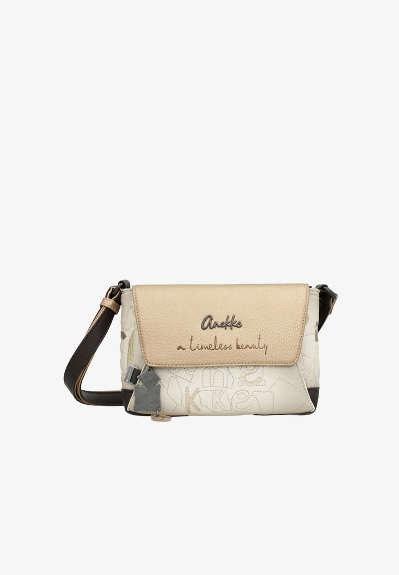 Beżowo-biała torba na ramię z klapką z napisem „Anekke a timeless beauty”, ozdobnym przeszyciem oraz ciemnym, regulowanym paskiem na ramię.