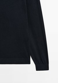 Navy blue knitted sweater with long sleeves, ribbed cuffs, and a smooth texture. Simple design, no patterns or visible hardware.