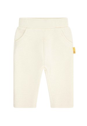 Pantaloni per bambini di colore crema morbido con vita elastica, tasche frontali e piccola etichetta gialla sulla cucitura laterale.