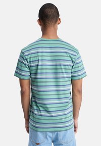 Striped short-sleeve t-shirt in green and blue tones, featuring horizontal stripes of varying widths and a crew neckline. Cotton blend material.