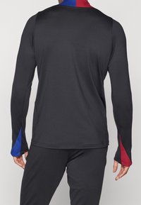 Schwarzes langärmliges Sportshirt mit blauen und roten Akzenten am Kragen und an den Ärmeln, aus einem glatten, dehnbaren Material gefertigt.