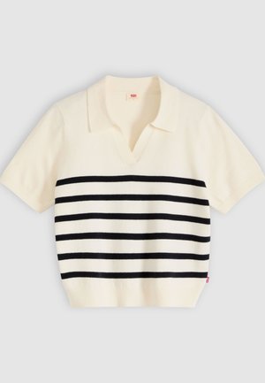 Polo de punto crema de manga corta con rayas horizontales negras, cuello abierto y dobladillo acanalado, presentado extendido sobre un fondo gris.