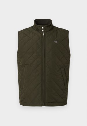 Gilet matelassé vert olive avec un col haut, fermeture éclair à l'avant et boutons-pression. Dispose de poches latérales et d'un petit logo sur la poitrine.