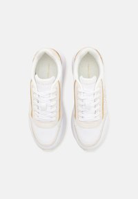 Sneaker bianche e beige con tomaia in pelle liscia, punta rotonda, collo imbottito e lacci piatti. Marchio visibile sui lati e sulla linguetta.