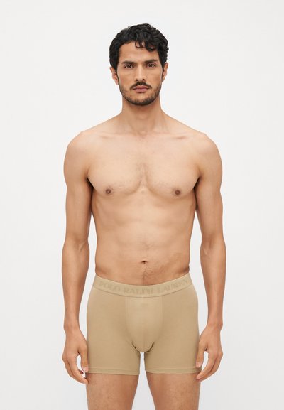Beige boxer alsónadrág elasztikus derékpánttal, amelyen a "POLO RALPH LAUREN" logó van gravírozva, sima, rugalmas pamut keverékből készült.