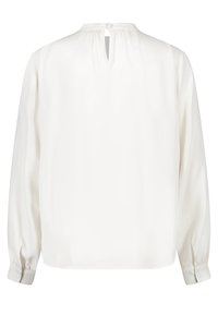 Blusa bianca, maniche lunghe, tessuto morbido, scollatura con una piccola apertura e chiusura con bottone sul retro, polsini con bottoni, vestibilità comoda.
