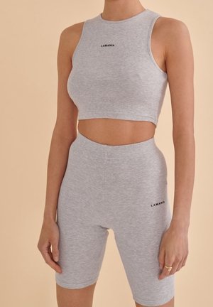 Sada šedého ribbovaného crop topu a kraťasů s vysokým pasem. Obsahuje malé černé logo "LAMANIA" na obou kusech. Hladká, elastická látka.