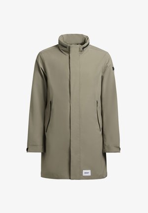 Chaqueta impermeable color caqui con alto cuello, mangas largas, cremallera frontal y dos bolsillos laterales con cremalleras negras y un parche con el logo en el dobladillo.