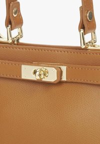 Handtas van lichtbruin leer met een gladde textuur, voorzien van gouden hardware en een gespsluiting. Korte handvatten met verstelbare riemen.