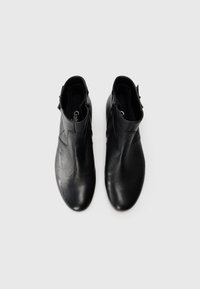 Pair of black leather ankle boots with side zippers and round toes on plain white background.