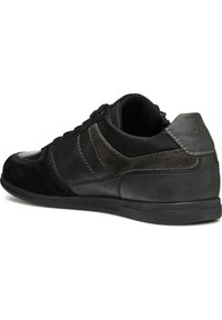 Baskets noires combinant cuir lisse et daim, avec un arrière texturé, des accents contrastés et une semelle en caoutchouc profilée basse.