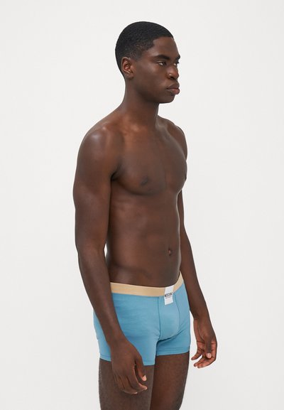 Blue boxer briefs with a beige waistband. The fabric appears smooth, fitted design. Label visible on the waistband.