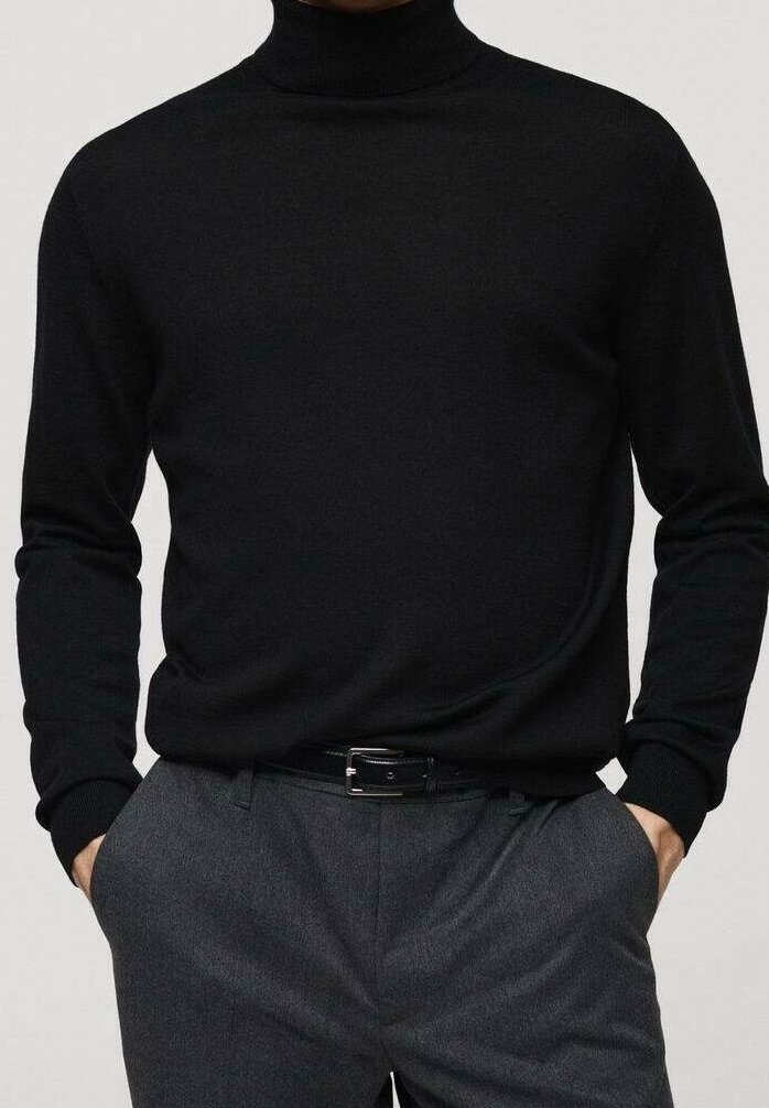 Černý rolákový svetr z měkké pleteniny. Má dlouhé rukávy a přiléhavý střih, kombinovaný se šedými kalhotami na míru a opaskem.