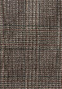 Tissu pied-de-poule marron et beige avec un motif à carreaux subtil en lignes rouges et vert foncé.