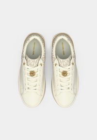 Sneakers bianche con superficie in pelle liscia e tacco in tessuto a fantasia. Dotate di dettagli in oro e suola beige chiaro. Branding "MICHAEL KORS" ben visibile.